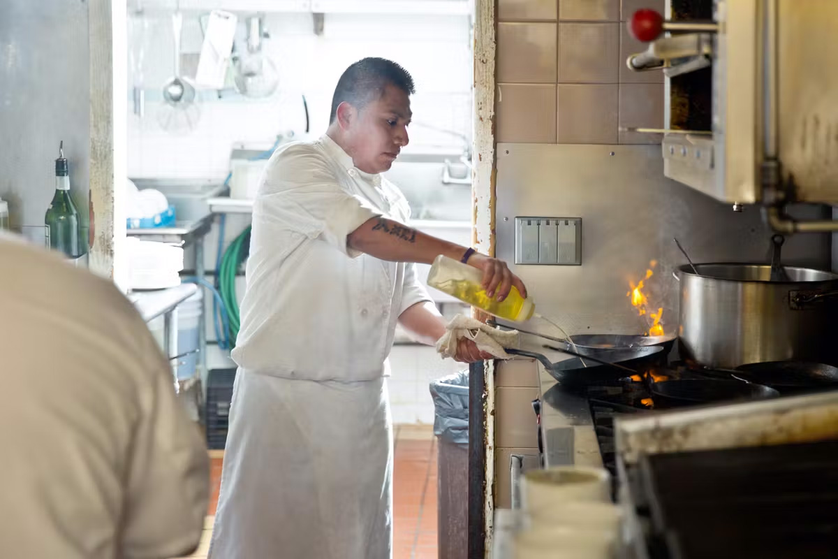 Chef cooking with pan fire at The Rail Stop Restaurant
